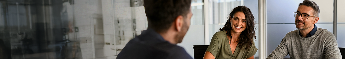 Three people meeting in an office boardroom.