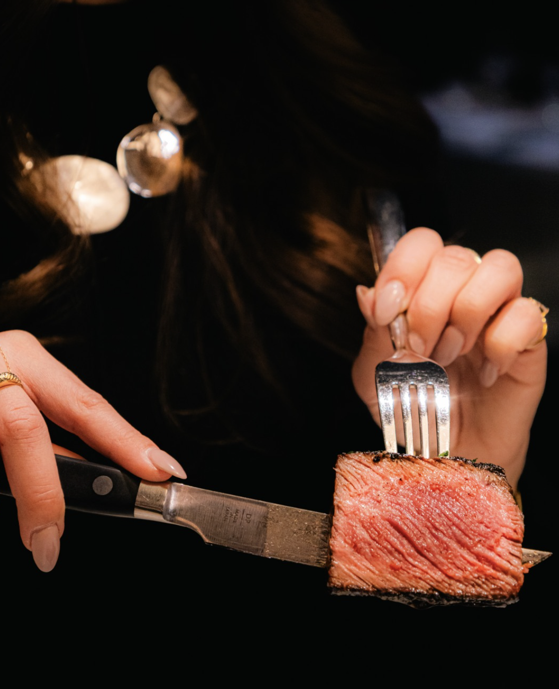 Juicy filet mignon steak on a fork.