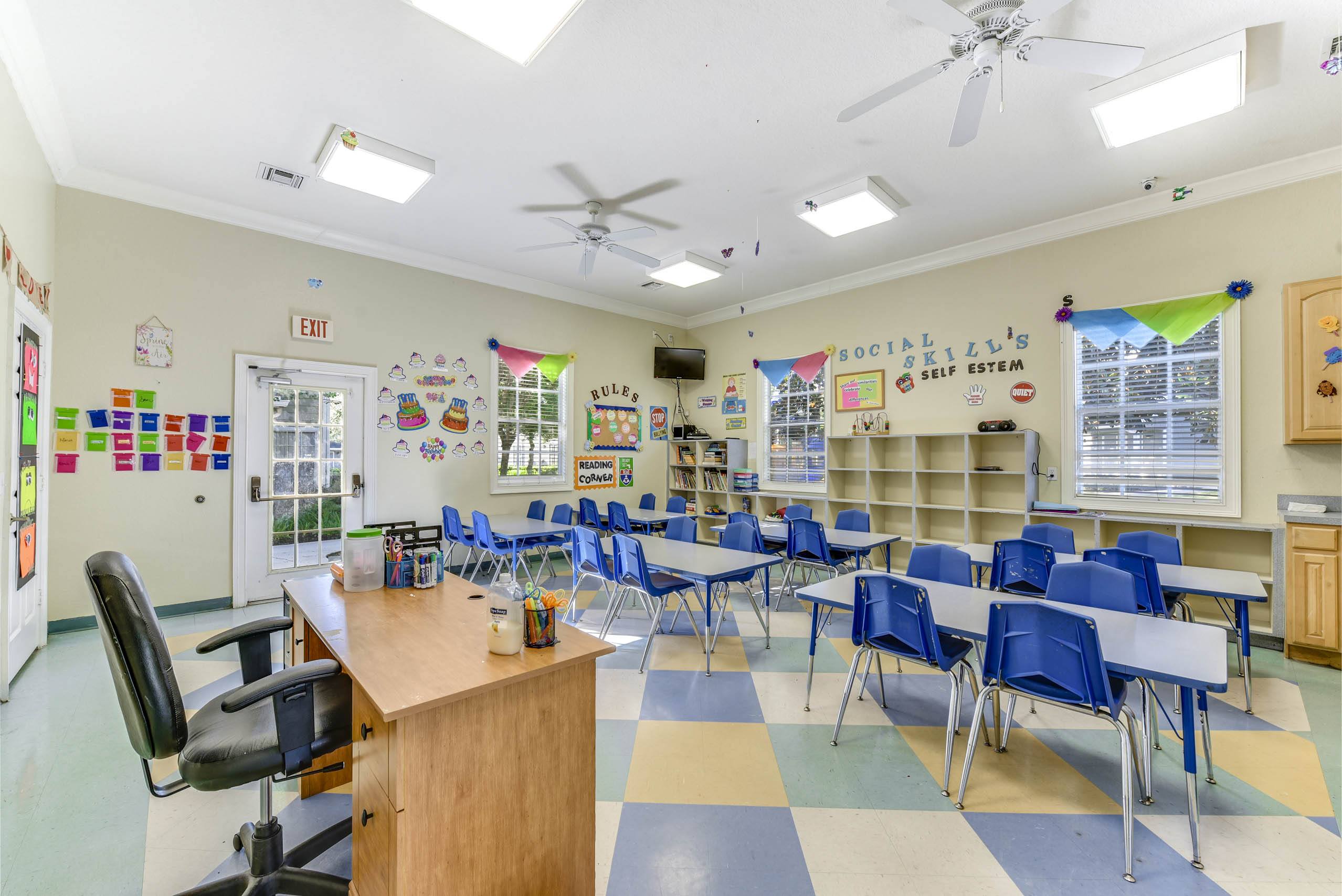 Classroom with a desk, chairs, and a whiteboard