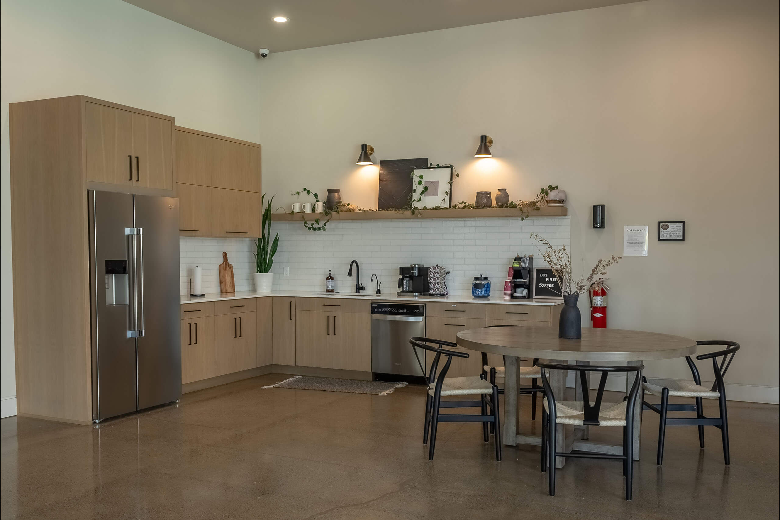 A modern kitchen with a refrigerator, sink, and dining table.