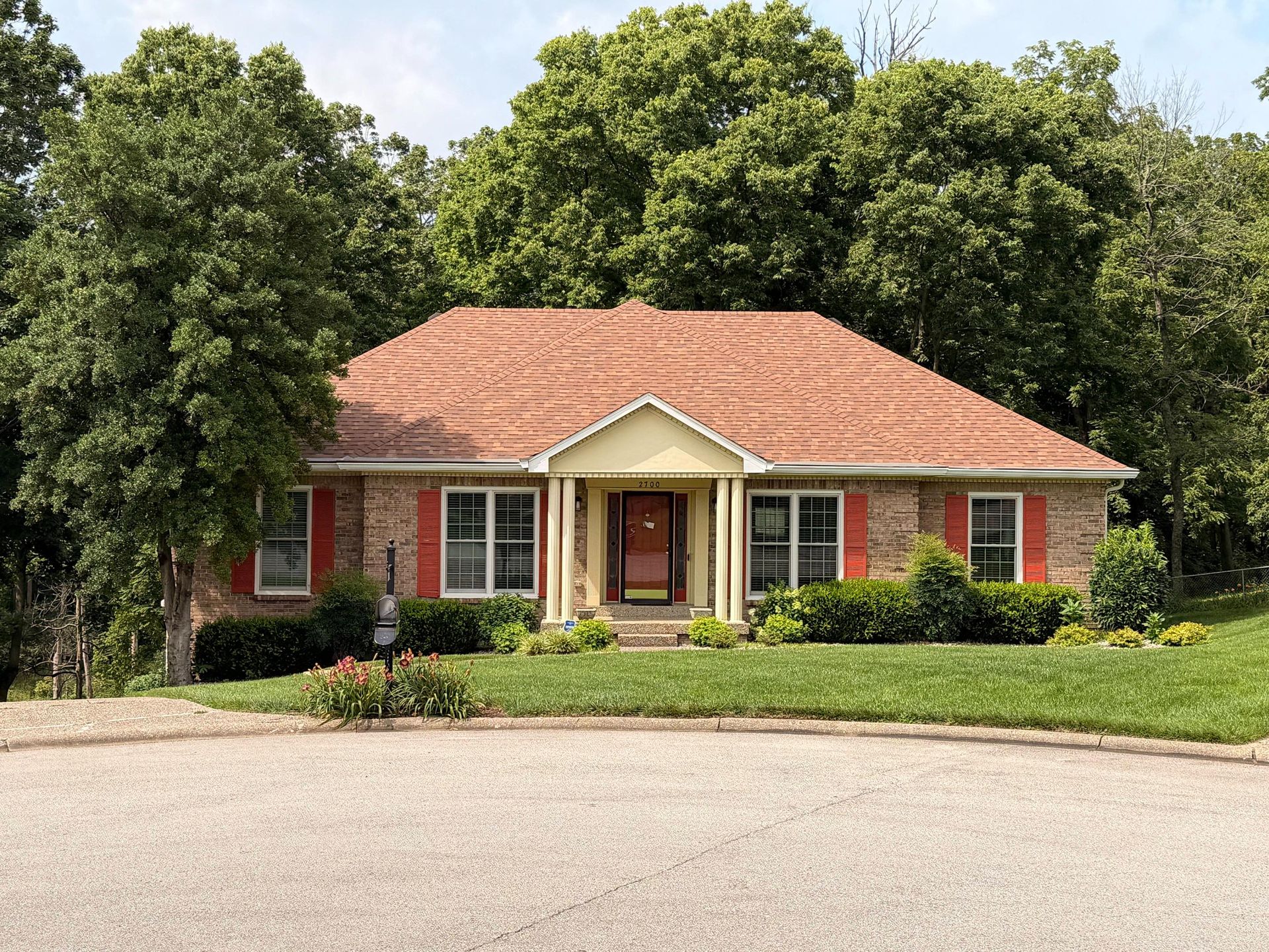 Single-story brick home featuring a newly completed architectural shingle roof in warm brown tones t 