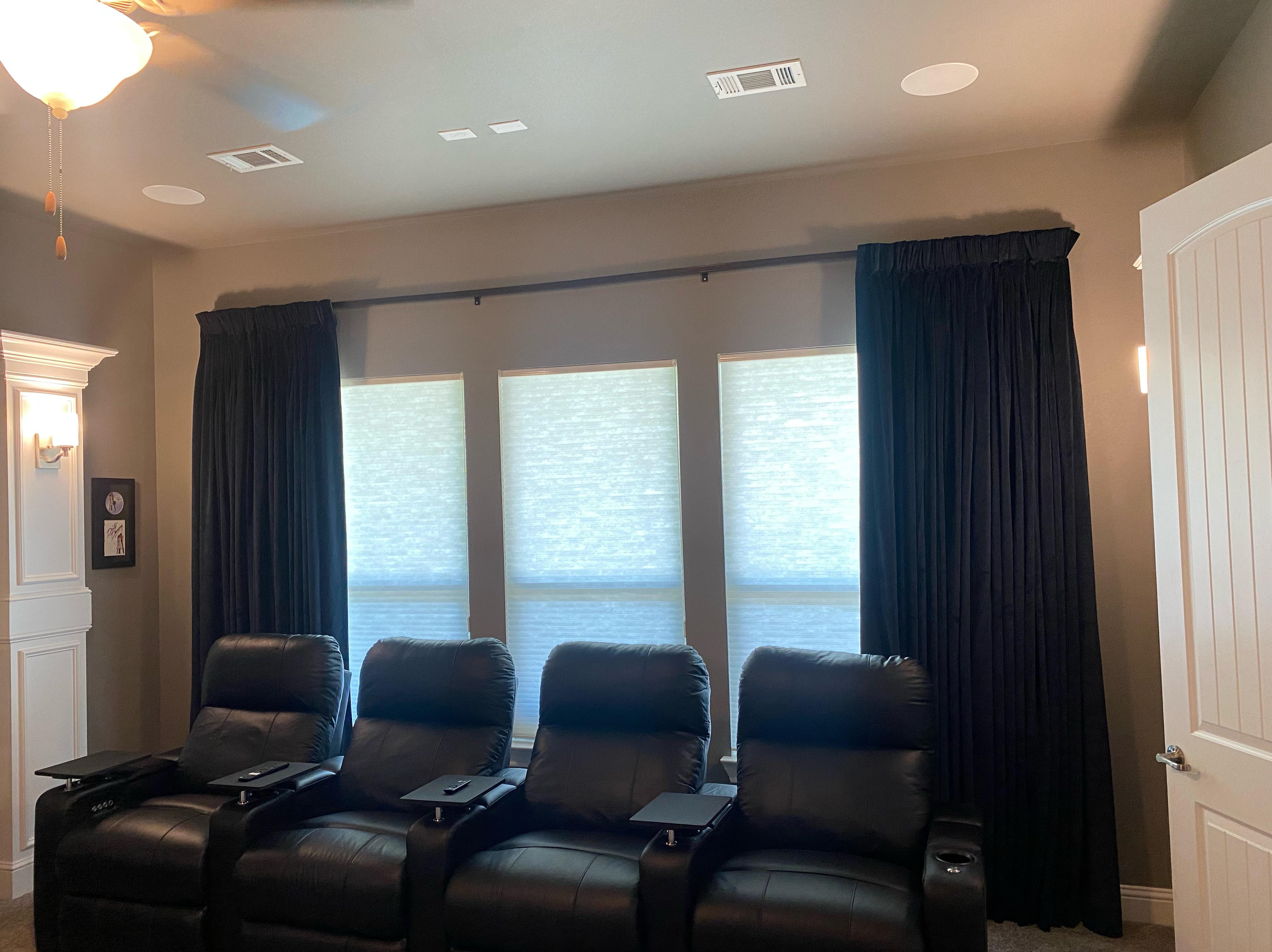 Light filtering cordless roller shades and motorized, black, felt drapery curtains have our client's media room in Heath, TX ready for movie night! Our design team at Budget Blinds of Rockwall, Terrell, and Greenville worked with our client to create the perfect movie viewing experience.