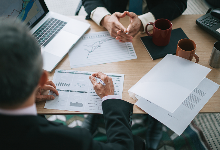 A close-up of wealth professionals reviewing graphs and charts.