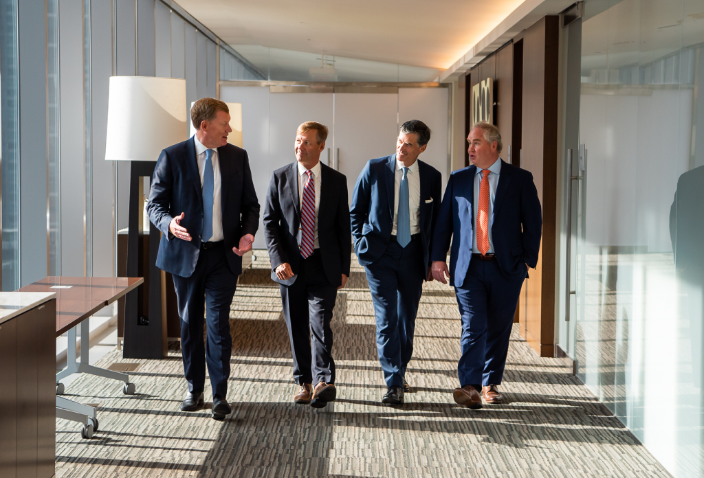 Chris Newall, Peter Coward, John Grant, and Graeme MacGregor walking side by side at the office.