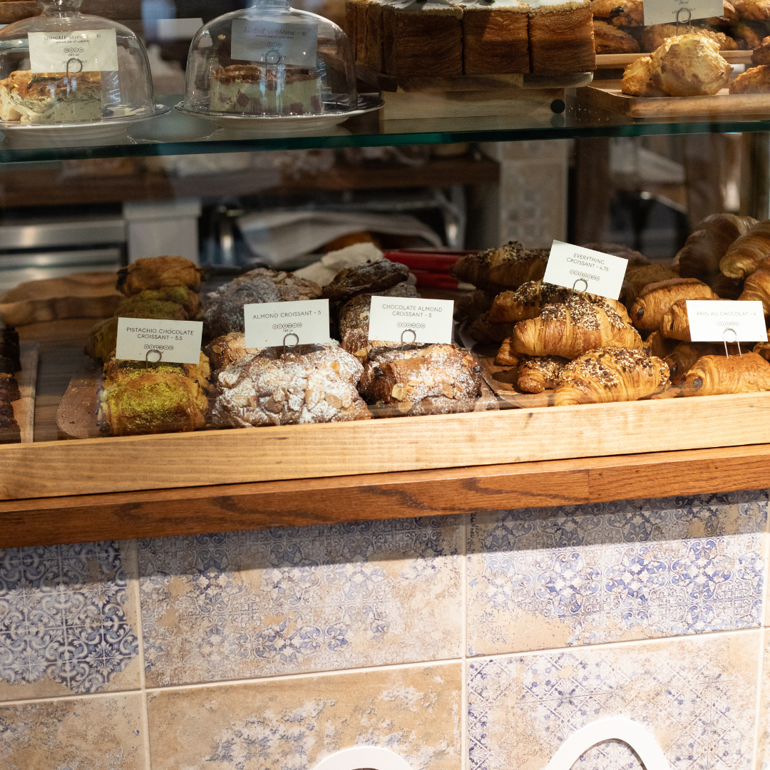 The pastry case at maman Park Cities features freshly baked croissants, cakes, cookies, and seasonal 