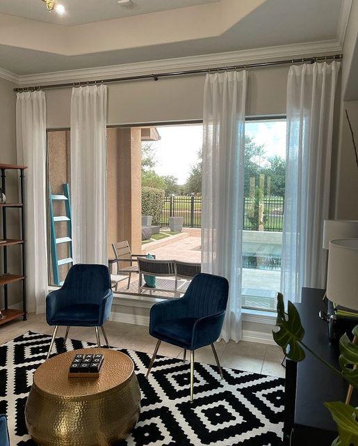 Even when you're in your office, you can still enjoy the poolside view. The elegant Drapes in this Katy, TX, home office make the room seem even bigger and brighter! #BudgetBlindsKatySugarLand #CustomInspiredDraperies #KatyTX #DrapedInBeauty #FreeConsultation #WindowWednesday