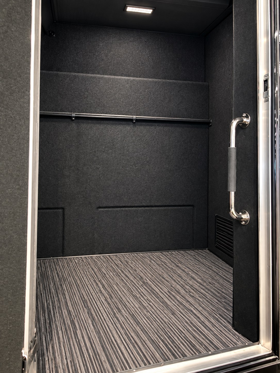 Shuttle luggage compartment with a wide access door and carpeted interior.