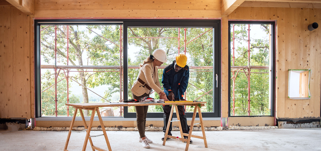 Two craftspeople working on the framing of a new home.