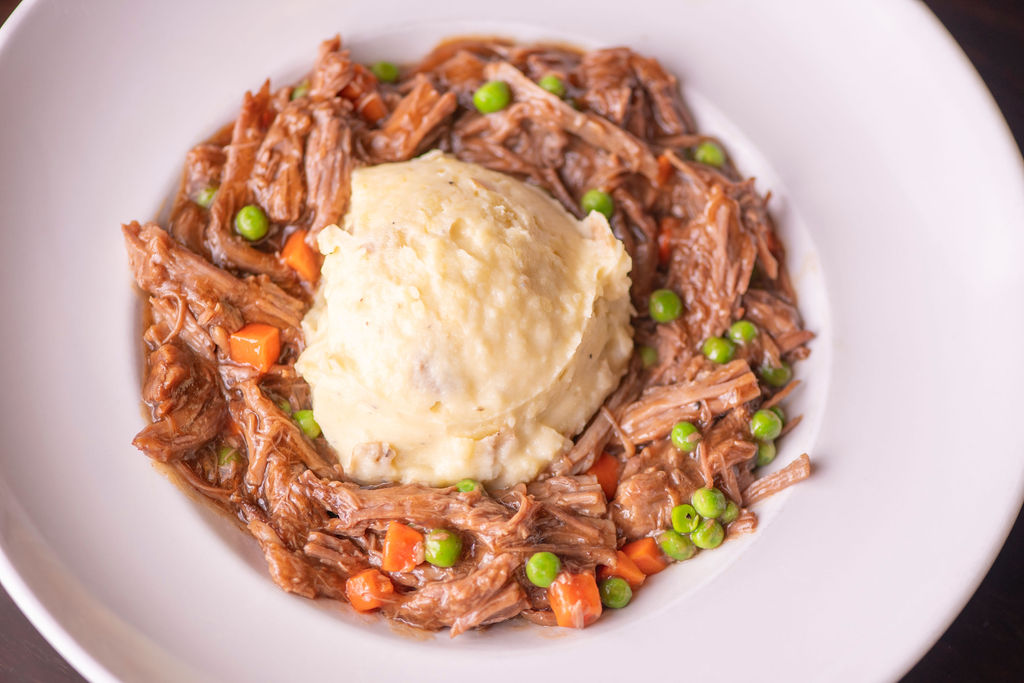shredded beef pot roast with house-made bordelaise, smashed potatoes, peas & carrots
