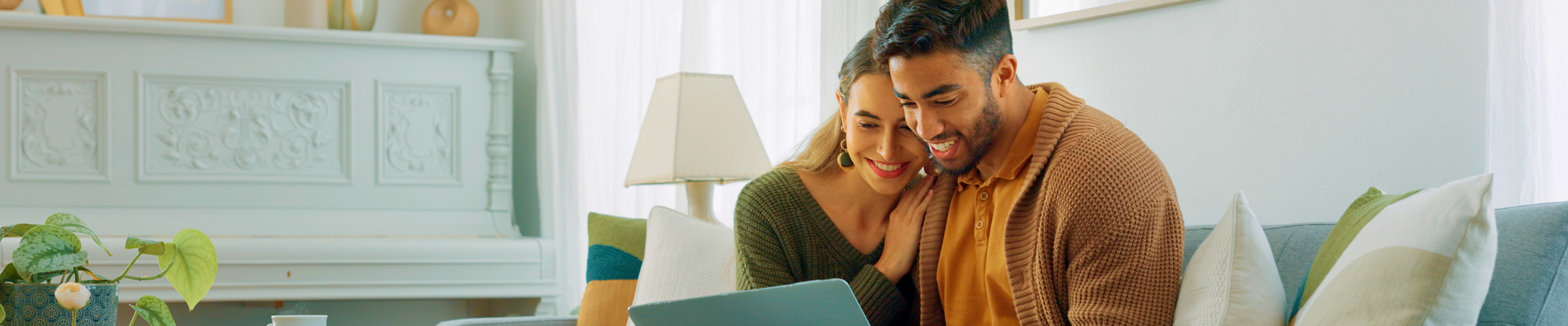 A couple on the couch looking at their iPad.