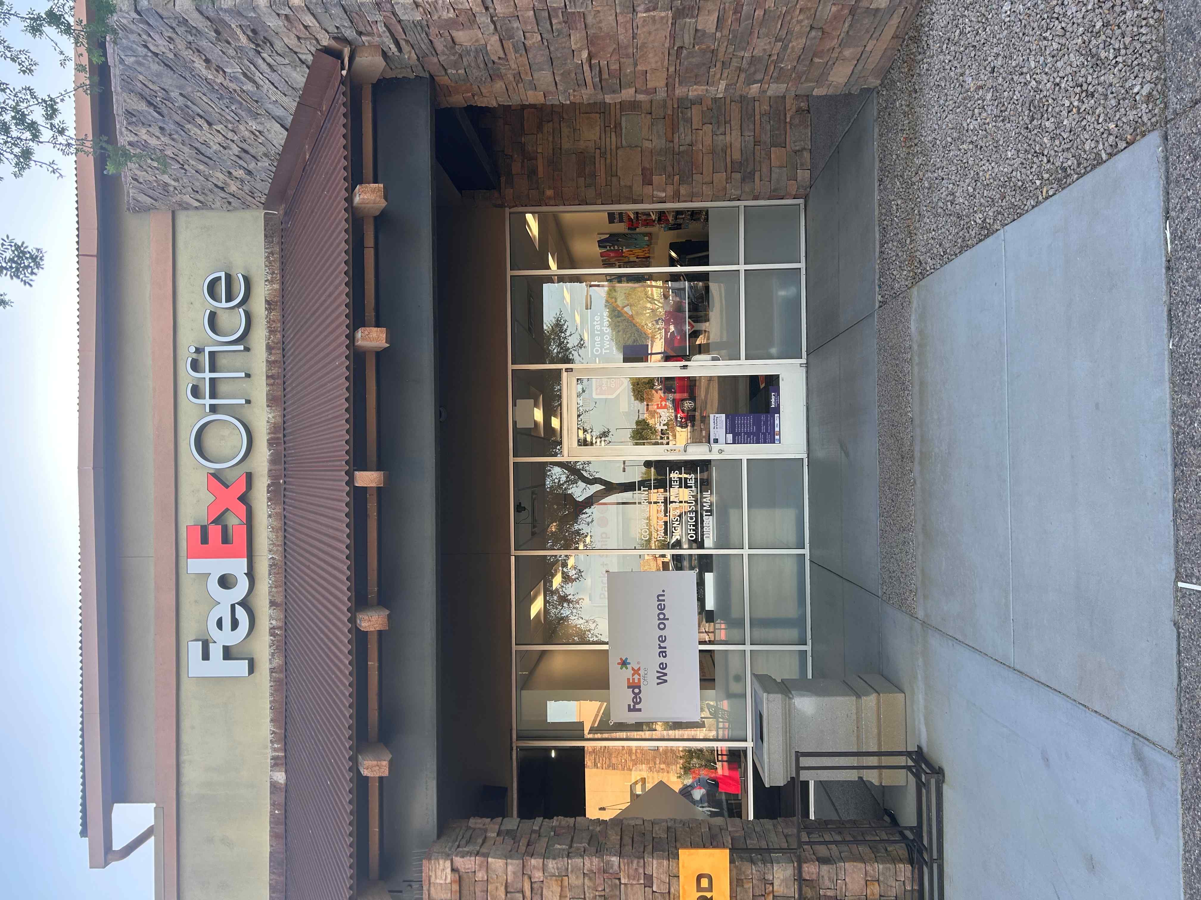 A direct view of the main glass-door entrance to the FedEx Office Print & Ship Center in Mesa, AZ. 