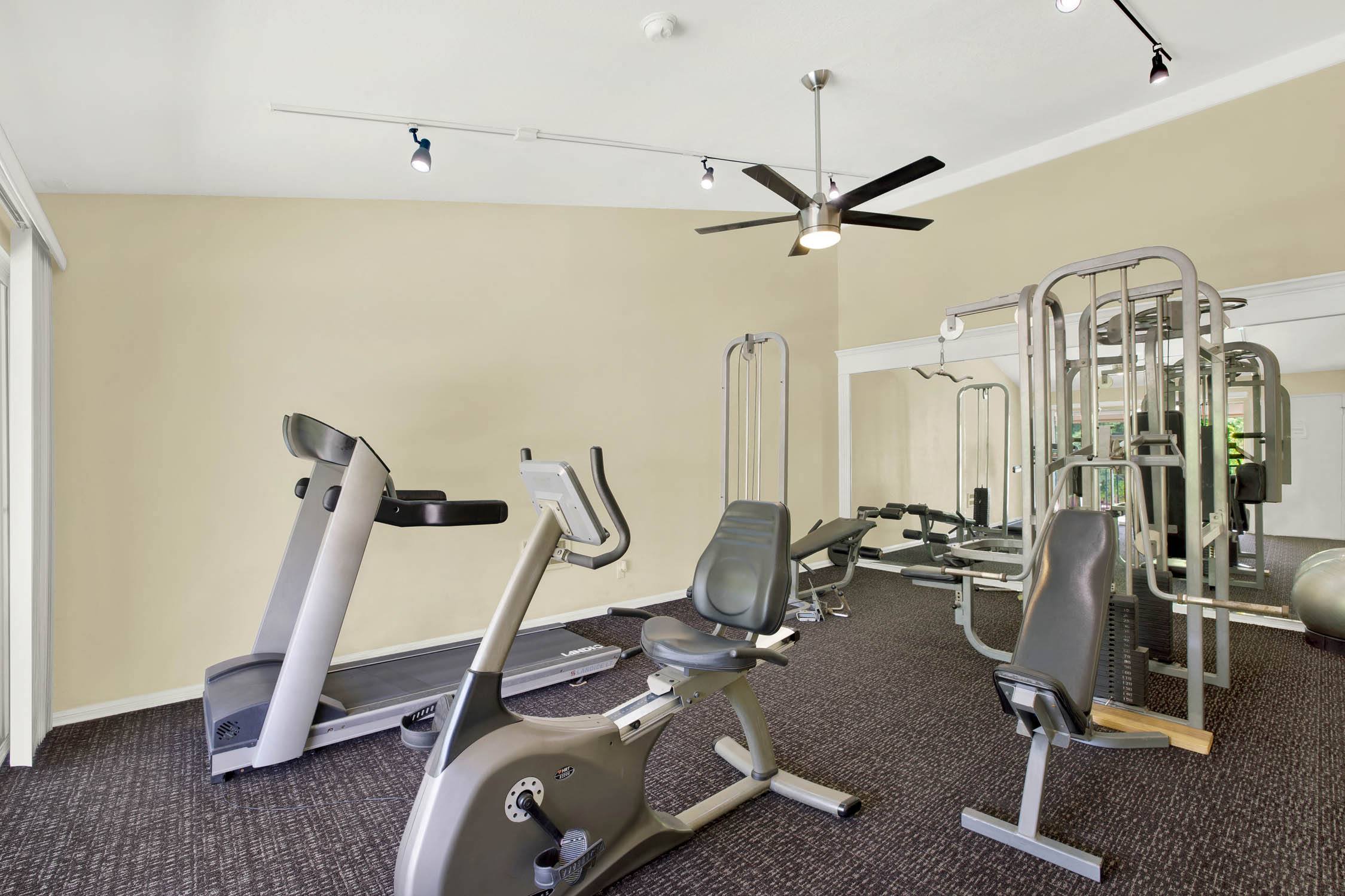 a gym with various exercise equipment on the floor