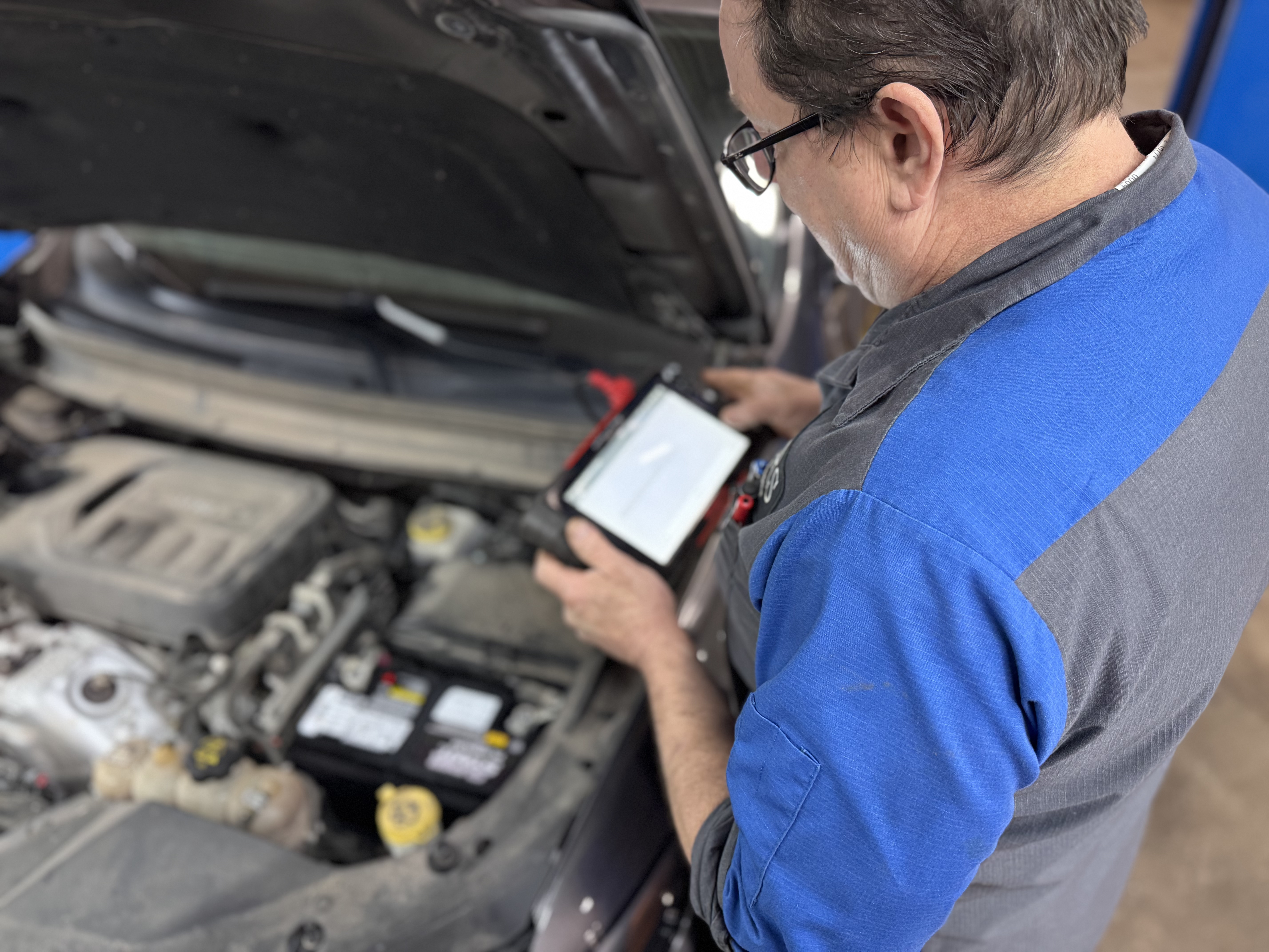 A CARS Auto Repair technician performing professional vehicle diagnostics and maintenance in Jenison, MI.