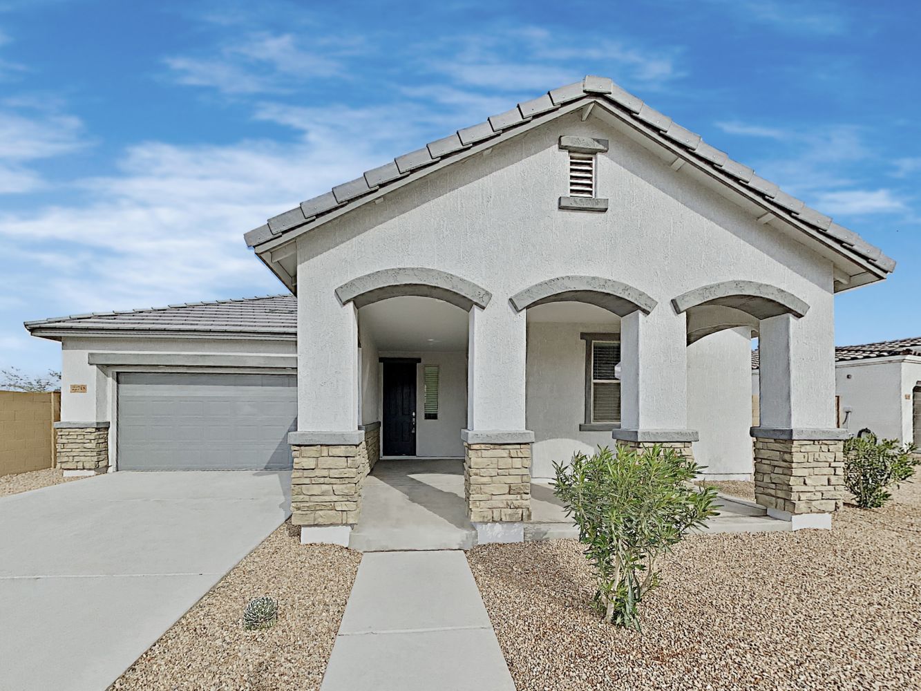 Grand front of home shot with luxurious covered patio and attached two-car garage at Invitation Homes Phoenix.