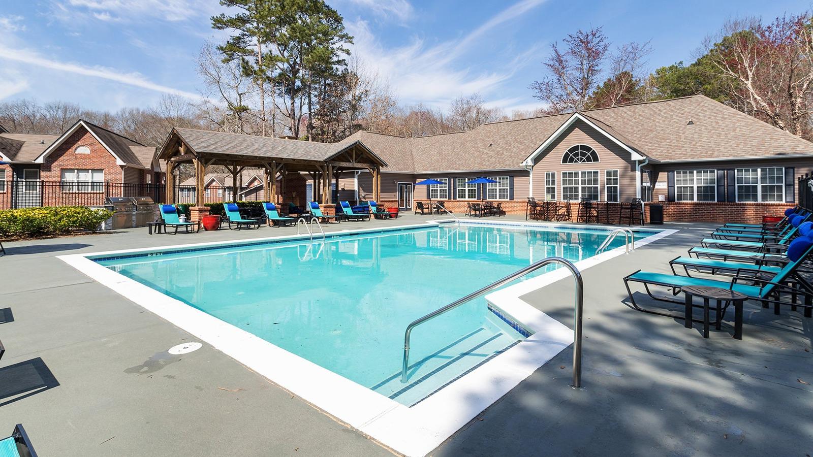 Pool surrounded by large sundeck with seating.