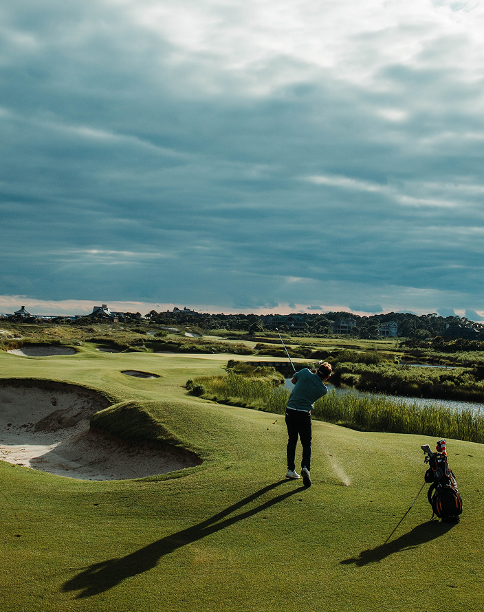 A man playing golf on a picturesque course.