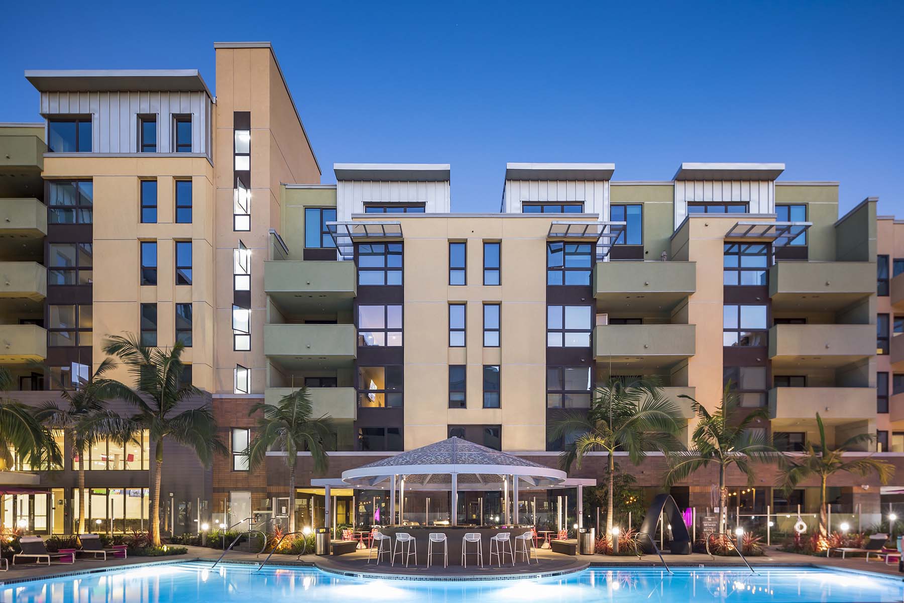 A large building with a pool in front of it.