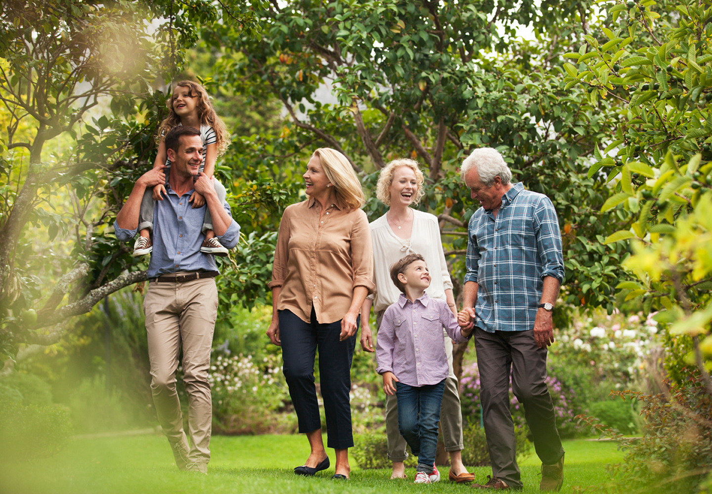 Multigenerational family walking through a lush garden.