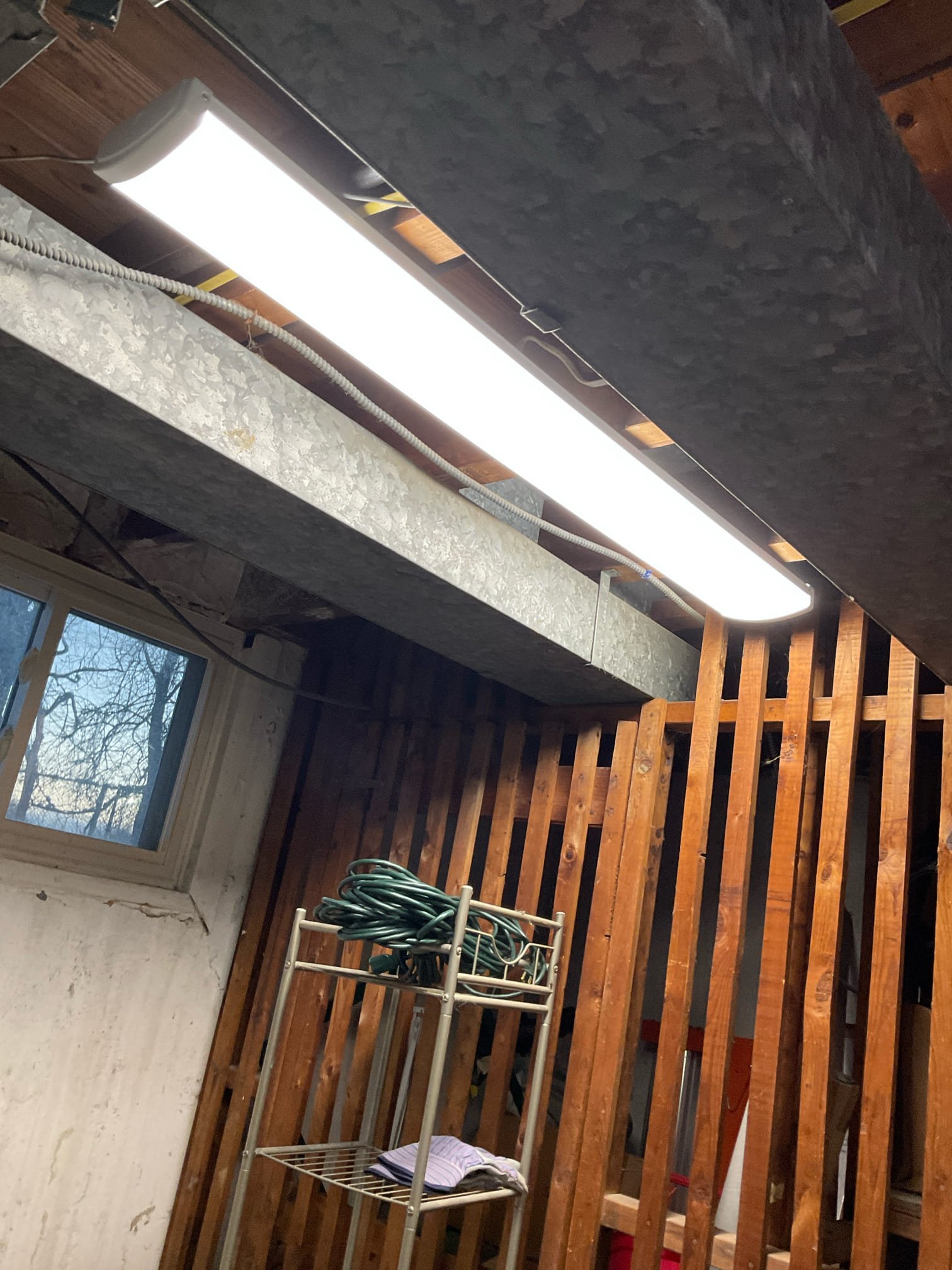 Thomas Edison Electric installed an LED wraparound light fixture in an unfinished basement in the Cottman Ave area of Philadelphia, PA. The bright, full-length fixture is wired with flexible metal conduit to the ceiling, providing strong task lighting for the storage and utility space.