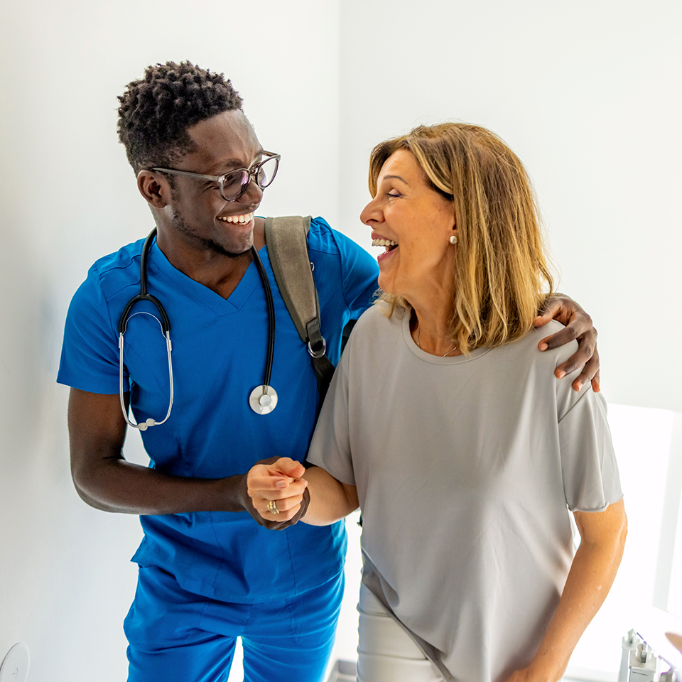 A man in scrubs walking alongside a woman.