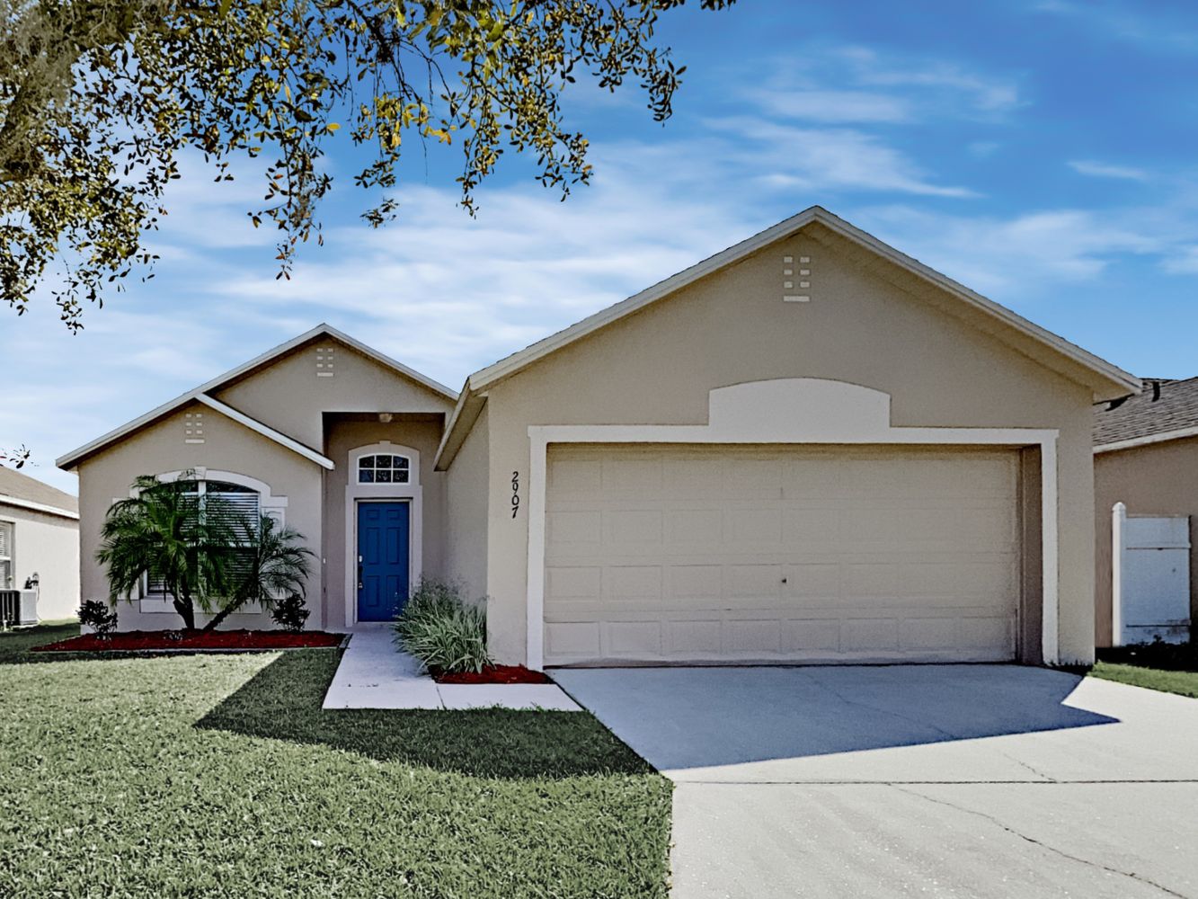 Modern home with a two-car garage and front lawn at Invitation Homes Orlando.