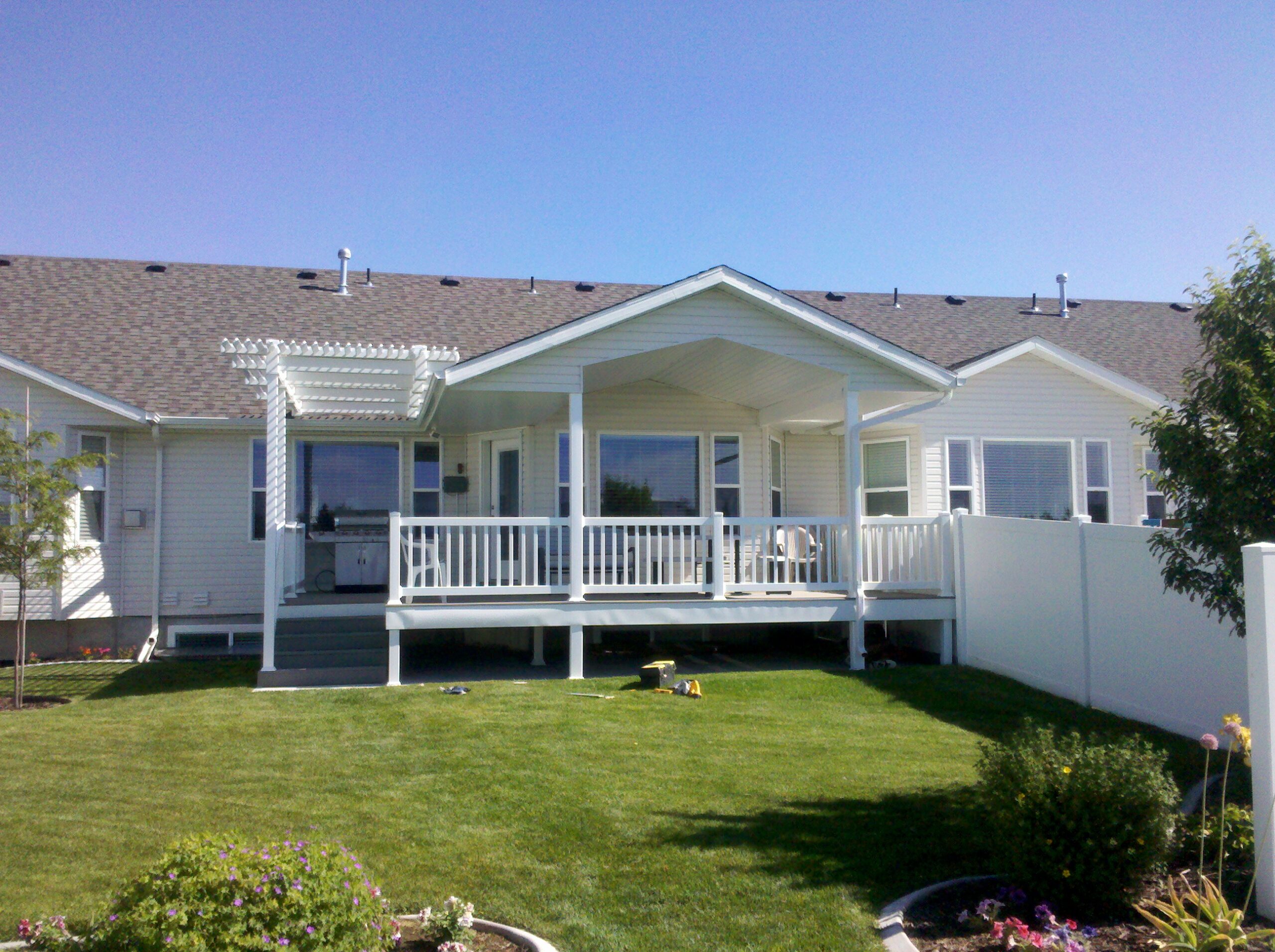 Get the best of both worlds with this custom DeckPro LLC project in Rexburg. This beautiful white deck features a solid gabled patio cover for complete shade and rain protection, seamlessly integrated with an attached pergola for filtered sunlight and style.
