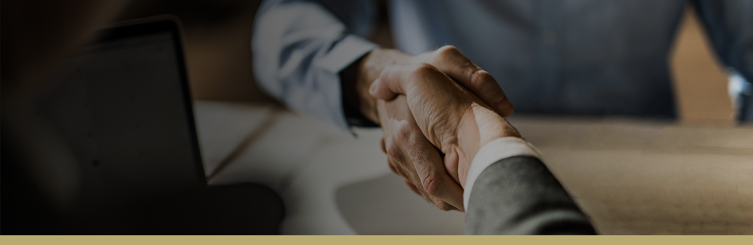 Close-up image of an advisor and client shaking hands.