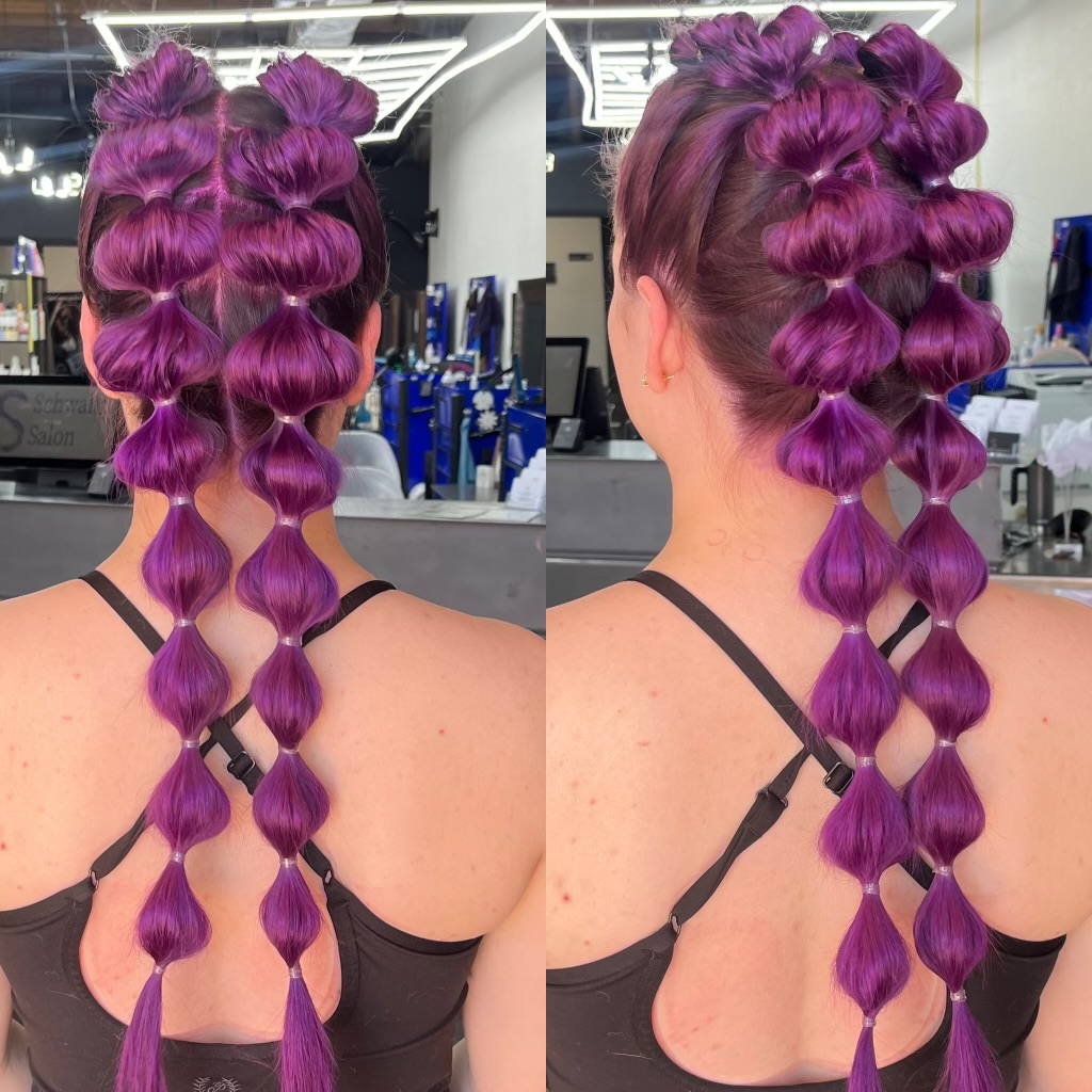 Bold purple hair color paired with a creative bubble braid style. This look highlights detailed styling strong structure and vibrant color payoff.