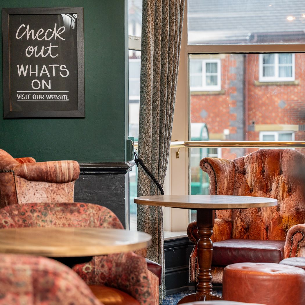 Comfortable armchair seating by the window, offering a relaxed spot for quiet drinks or conversation.