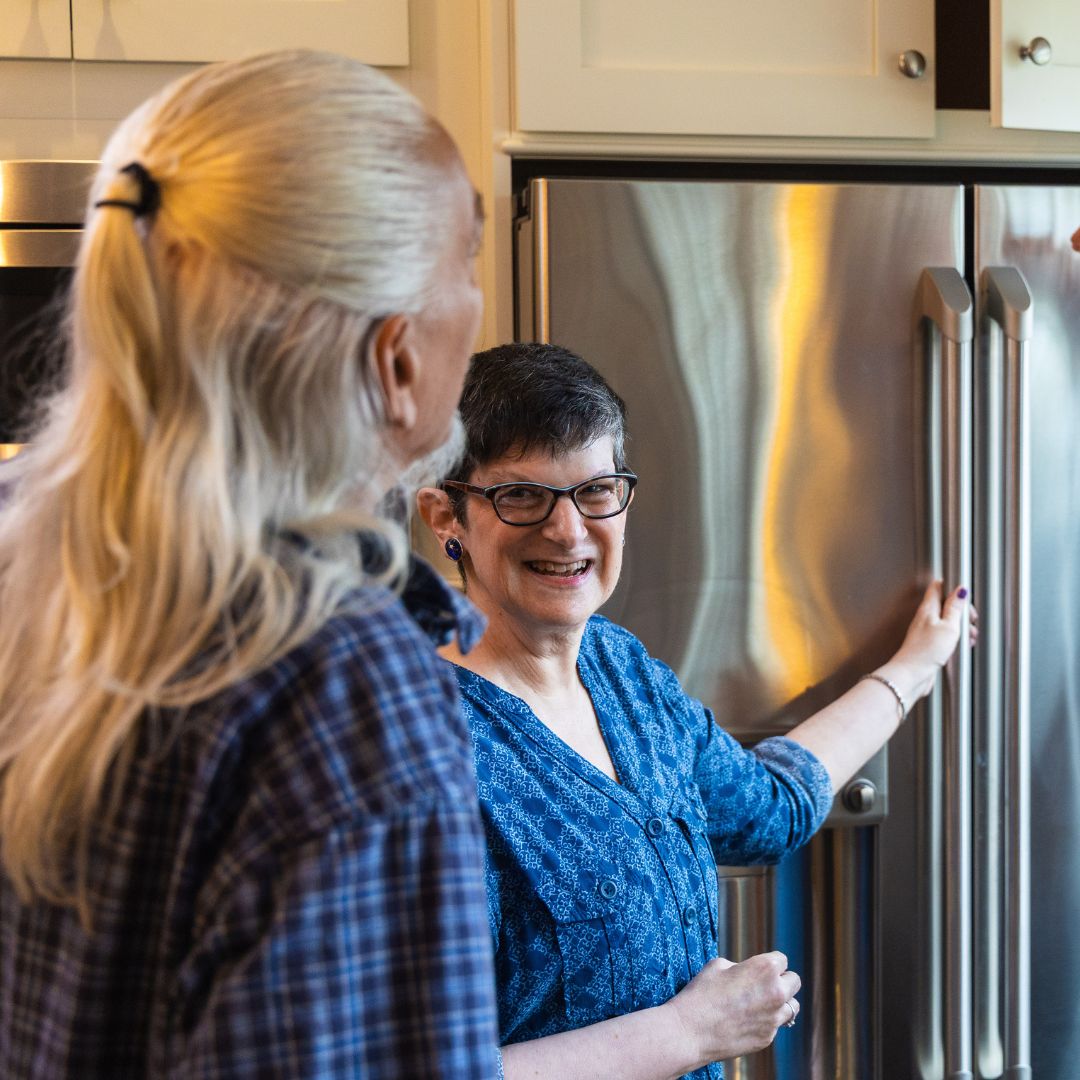 A joyful moment captured as a client engages in the kitchen remodel process with her partner.