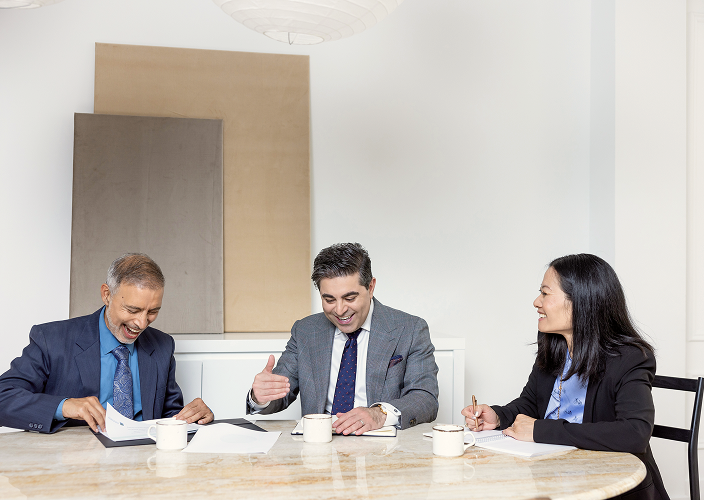 The Naman Private Wealth team laughing together during a meeting.