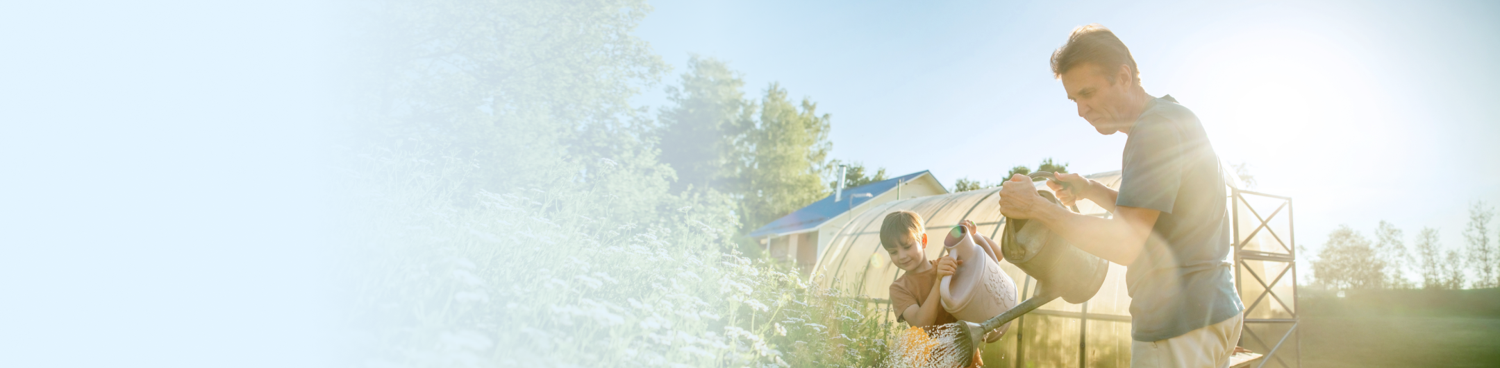 A grandfather and grandson gardening together.