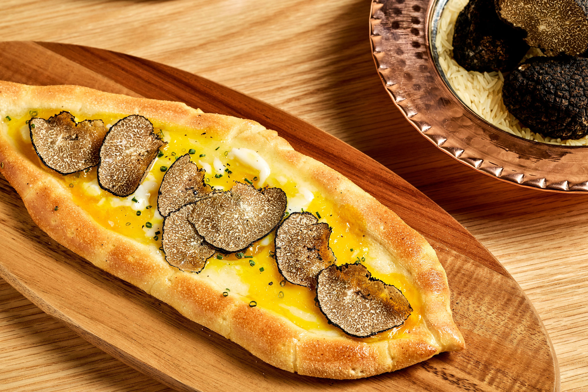 A pide, or flatbread, with kasar cheese topped with 65° egg and black summer truffle 
