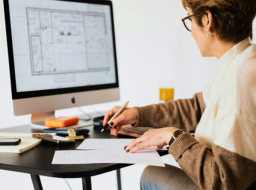 A person reviewing a floor plan on a desktop computer screen.