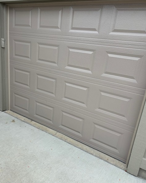 Residential raised-panel sectional garage door with a neutral taupe finish, installed by Highfield Door Sales in Beavercreek, Ohio. This classic panel design offers durability, a clean appearance, and reliable everyday performance.