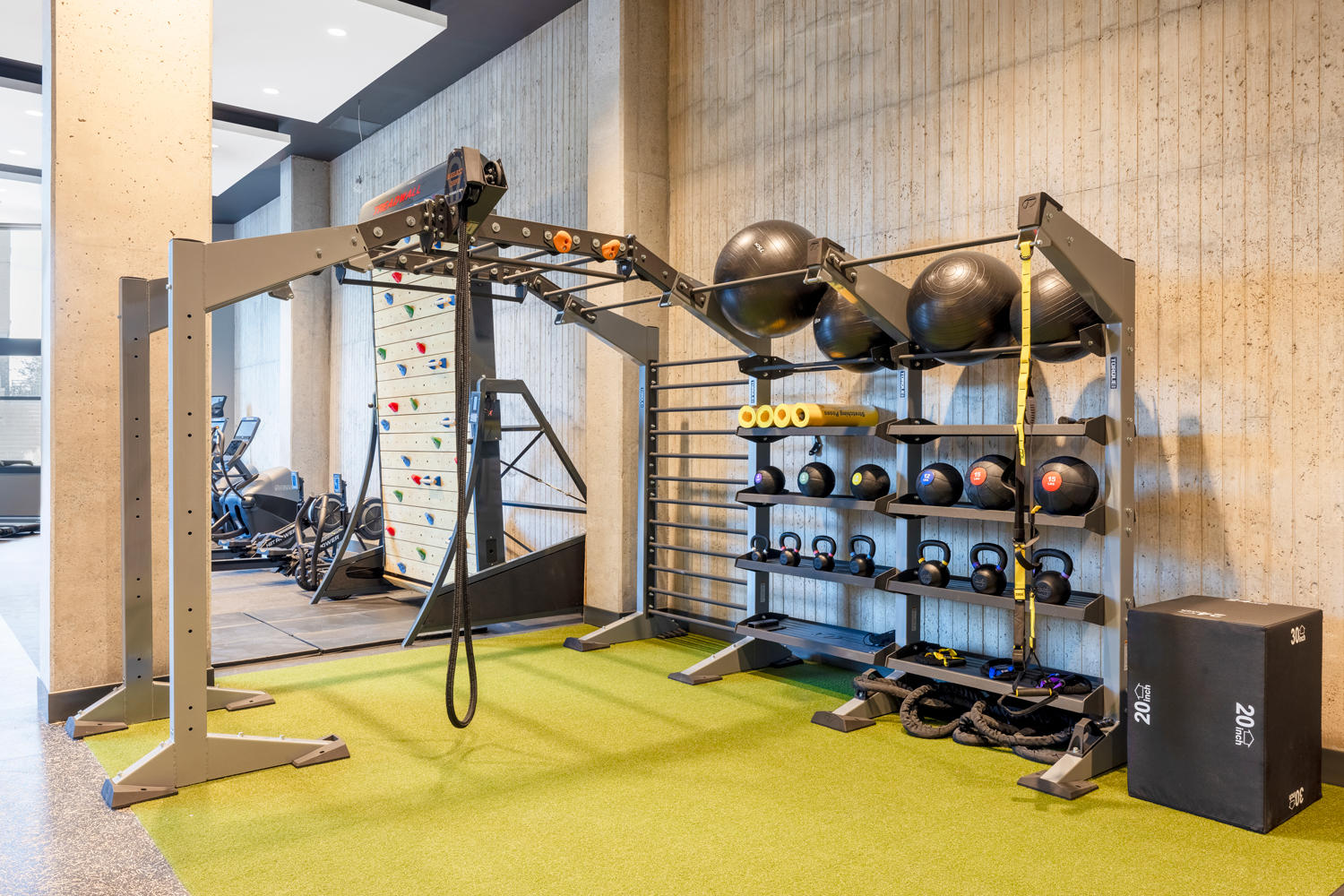 Modern exercise equipment and turf area for full-body strength training.