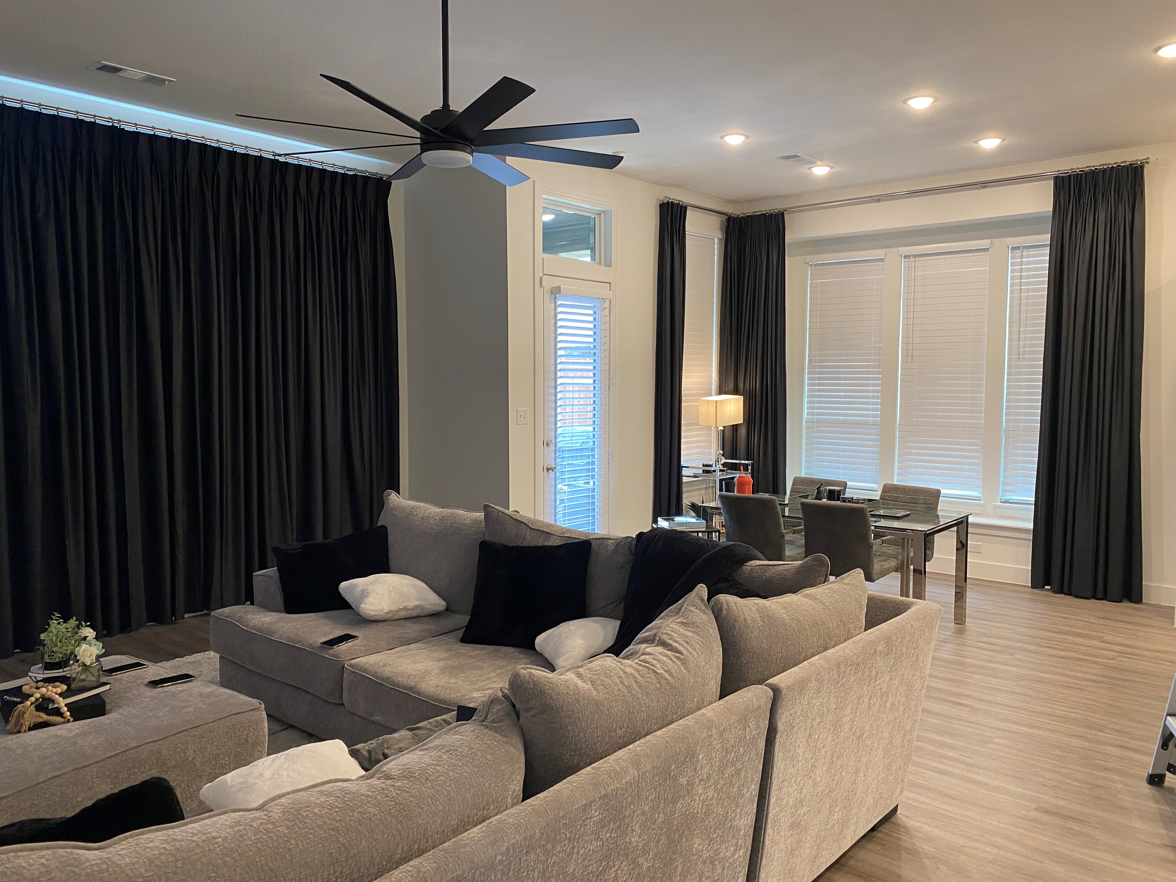 The team at Budget Blinds of Rockwall, Terrell, and Greenville absolutely love the clean, modern look of drapery paired with white faux wood blinds for a living room and office combo.