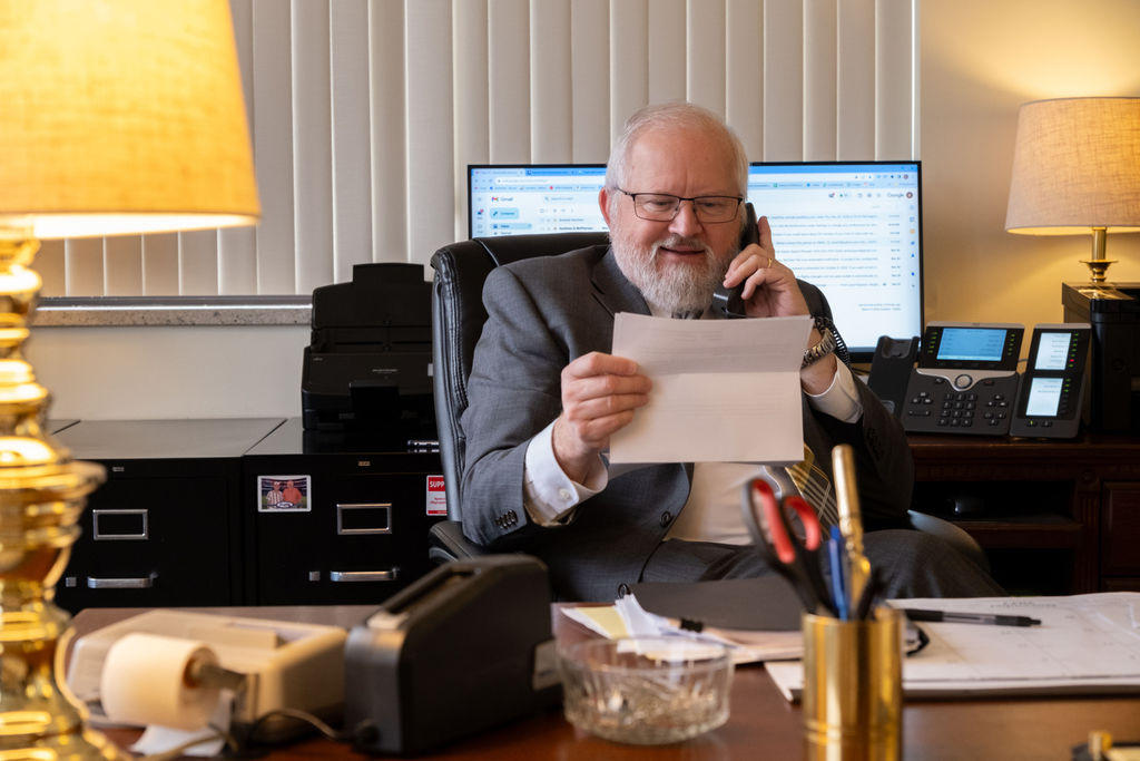 Kevin Kaufman speaking over the phone with a client reviewing details.