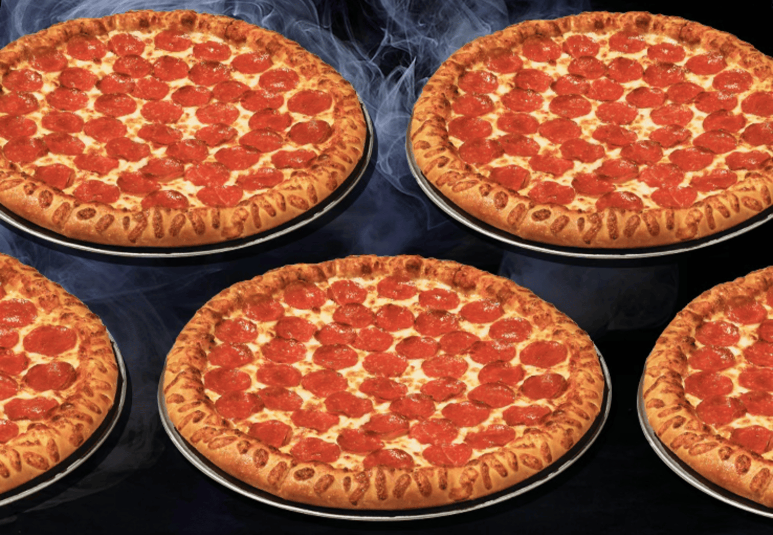 Pizza Hut pepperoni pizzas on a dark, smoky Halloween background