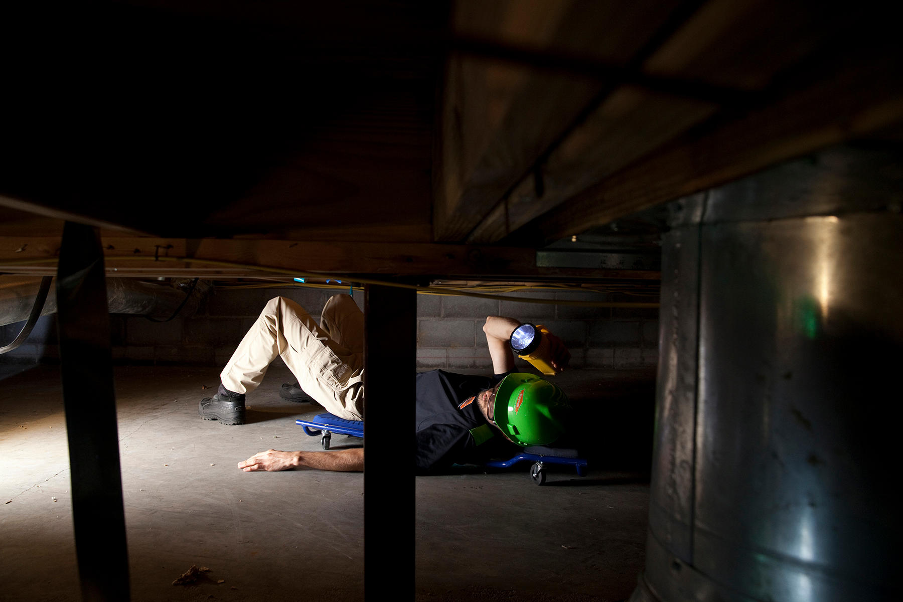 SERVPRO of Charlottesville technician carefully examining the subfloor in a crawlspace for water and mold damage.