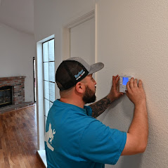 A trusted service technician installing a digital programable thermostat.