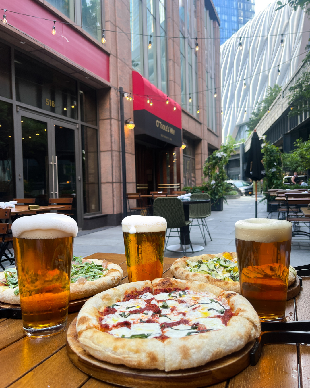 Pizza and beer on an outdoor patio table at O'Toole's Way.