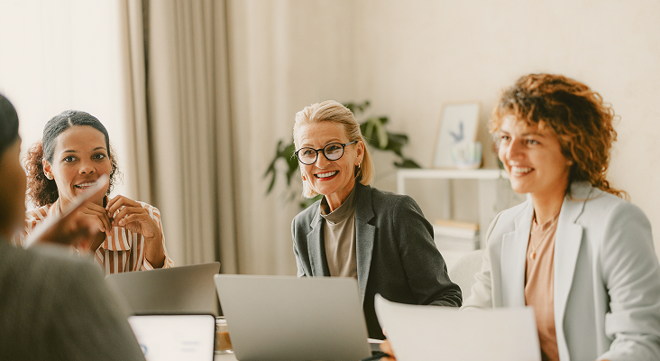 Professionals in the middle of a meeting with their laptops open.