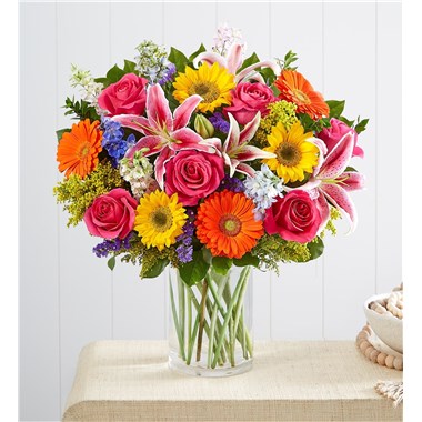 A fresh-from-the meadow design makes our bouquet a true delight. Vibrant blooms and lush greenery are brought together for a rich contrast of color. Arranged in a clear vase to let its beauty shine, this summertime standout deserves to be put on display. All-around arrangement with sunflowers, hot pink roses, pink Oriental lilies and larkspur, blue delphinium, orange Gerbera daisies and purple statice; accented with assorted greenery Artistically designed in a clear glass cylinder vase; measures 8"H Our florists hand-design each arrangement, so colors, varieties and container may vary due to local availability To ensure lasting beauty, Oriental lilies may arrive in bud form and will fully bloom over the next few days Sunflowers may arrive with light or dark centers