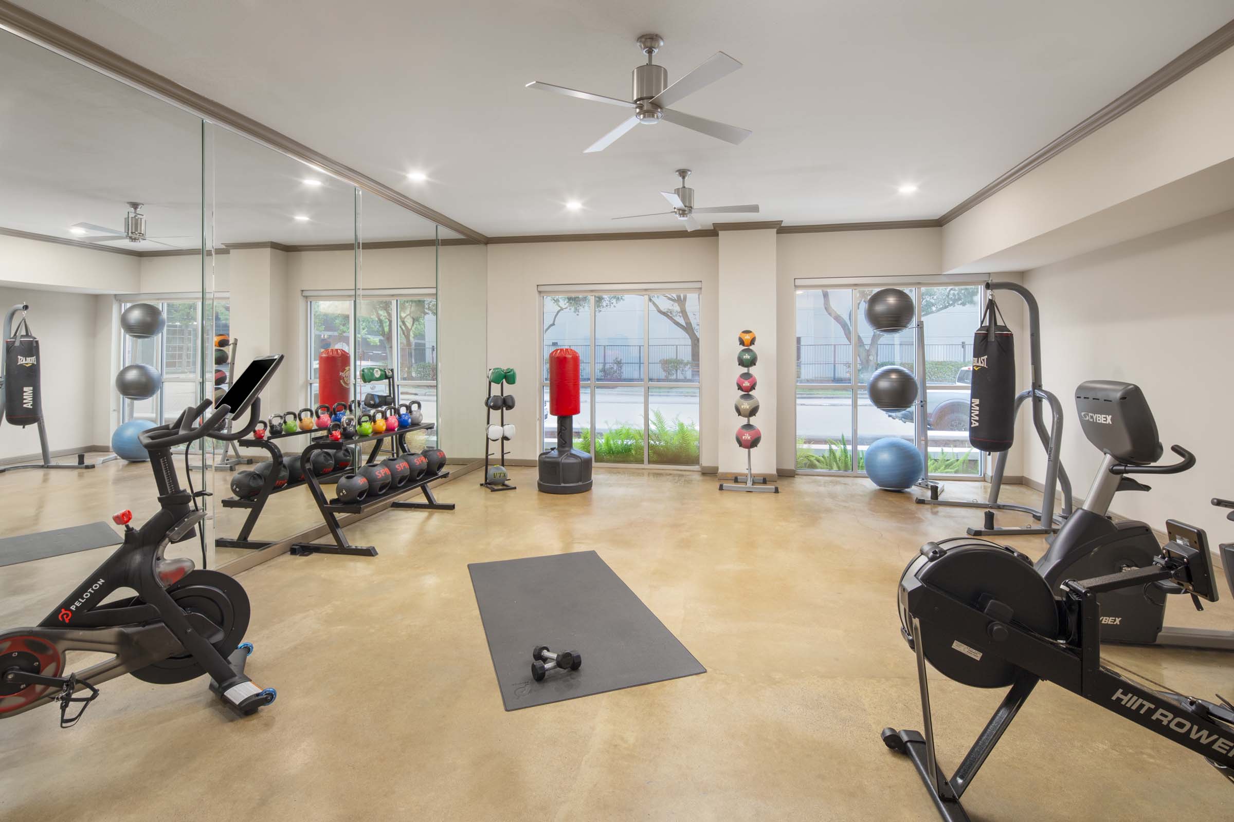 Fitness center with studio for stretching, riding the peloton, rowing and kickboxing at Camden Plaza Apartments in Houston, TX