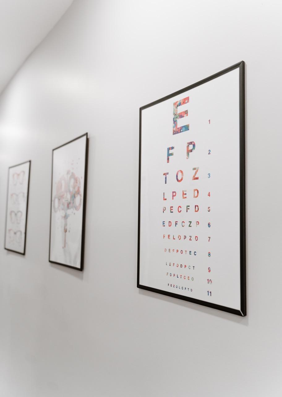 Colorful visual acuity eye chart mounted on a wall inside TK Optometry's Brooklyn eye care office. 
