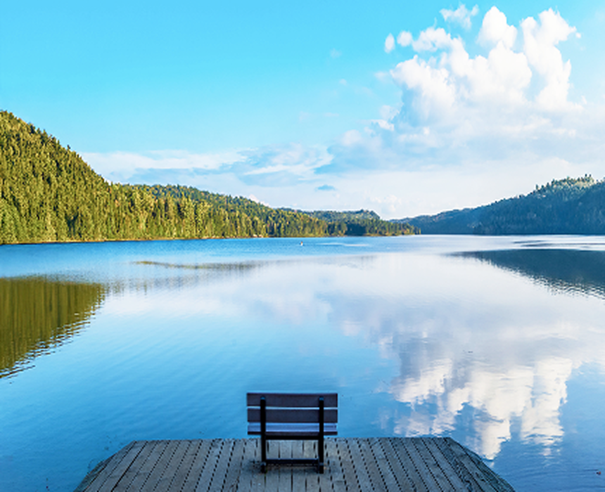 A serene scene of a bench on a boardwalk overlooking La Mauricie National Park.