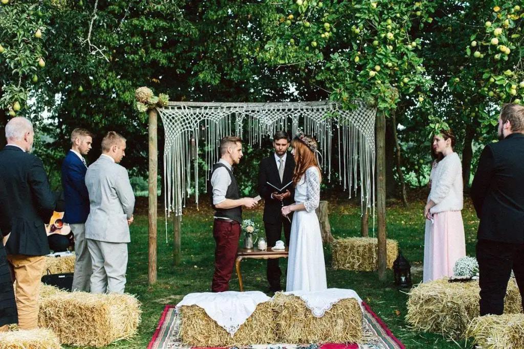 In einem dichten Wald stehen Braut und Bräutigam unter freiem Himmel und feiern ihre Trauung