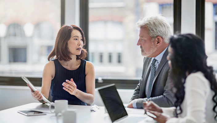 An advisor in a meeting with two other professionals.