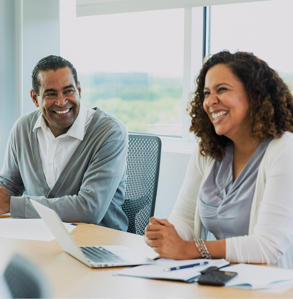 People in a business meeting smiling.
